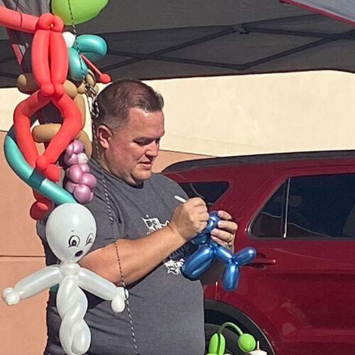 man twisting balloons