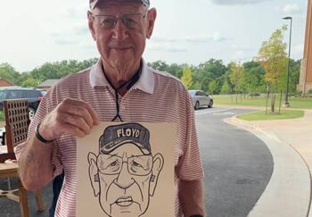 man holding caricature drawing