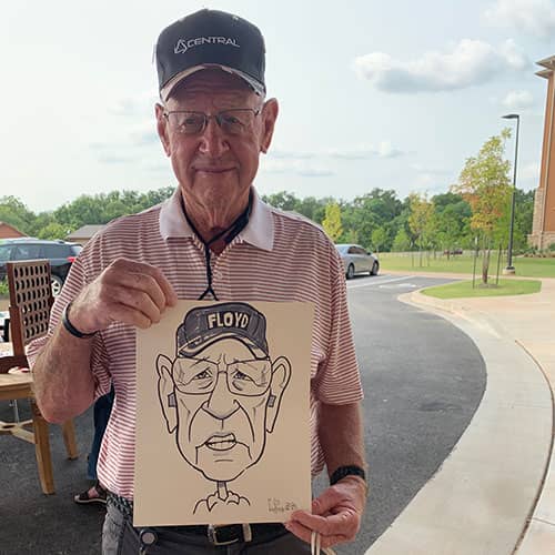 man holding caricature drawing