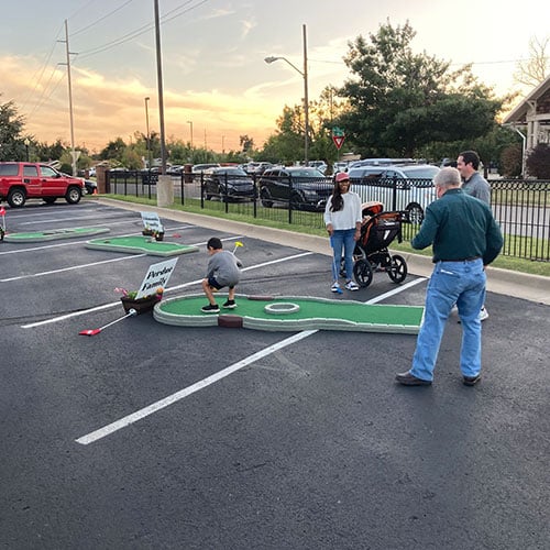 people playing mini golf in parking lot