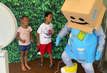 robot mascot with kids at photo booth